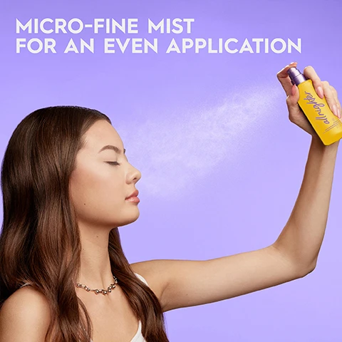Image 1 - A woman with closed eyes sprays mist from a yellow bottle towards her face MICRO-FINE MIST FOR AN EVEN APPLICATION. Image 2 - Close-up of a yellow spray bottle with a purple nozzle spraying mist on a purple background, with text overlay UP TO 16HR STAYING POWER* WITH VITAMIN C, TO BRIGHTEN APPEARANCE OF SKIN *CONSUMER TEST WITH 50 PARTICIPANTS. Image 3 - Three yellow makeup setting spray bottles in different sizes on a purple background labeled TRAVEL SIZE 30ML FULL SIZE 118ML JUMBO SIZE 240ML. Image 4 - Four Urban Decay All Nighter setting spray bottles in light purple, dark purple, black, and yellow are displayed on rocks: DEWY Extra Glow, MATTE Ultra Matte, THE OG Long Lasting Makeup Setting Spray, and HYDRATING Cactus Flower Water Vitamin C.