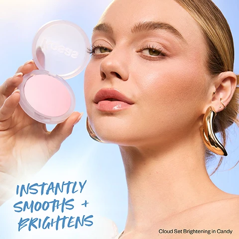 Image 1 - A person with light skin and long hair poses with a pink compact powder in their hand, wearing large gold earrings, with the text INSTANLY SMOOTHs + BRIGHTENS and Cloud Set Brightening in Candy visible.
Image 2 - Image features three close-up portraits of women showcasing glowy skin, with the text below stating Candy for Very Light to Light Medium skin tones.
Image 3 - A young woman with long, dark hair is shown with highlighted areas under her eyes and around her mouth, holding a translucent compact that contains a light pink powder, with visible text that reads HOW TO Apply on targeted areas to instantly brighten Cloud Set Brightening in Candy.
Image 4 - Image shows various shades of makeup compacts floating against a light blue background, with text stating Baked With Liquid Skincare, 100% saw improved skin smoothness, texture and even skintone*, 100% saw visible reduction in appearance of pores*, Non-comedogenic, Non-acnegenic, Safe for sensitive skin, based on a clinical measurement study after wearing Cloud Set for 8 hours.
Image 5 - A close-up view of various makeup powders in pink, yellow, and peach shades arranged in a swirl pattern with text that reads Pink, yellow + peach shades instantly brighten + cancel darkness, Sweeps away shine (not glow), Real-skin finish, Talc-Free + Vegan.
Image 6 - Image shows three circular shades of baked powder with textures: a yellow shade labeled Buttery, a pink shade labeled Candy, and a peach shade labeled Peachy, along with text at the bottom stating NEW! Bestselling baked powder, now with a brightening boost.