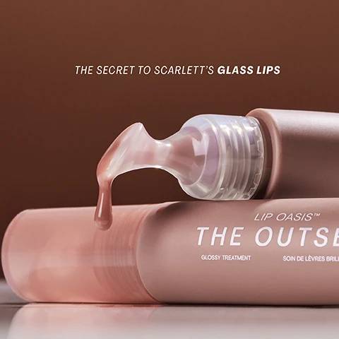 Image 1 - A close-up image of a lip gloss tube with a shiny, pinkish formula being dispensed from the applicator, featuring the text THE SECRET TO SCARLETT’S GLASS LIPS and LIP OASIS™ THE OUTSET GLOSSY TREATMENT.
Image 2 - A close-up of a womans face showing her lips with dewy gloss, alongside text that reads Intense Moisture boosts lip hydration by 48% in 4 weeks, Gentle Plumping powered by Maxilip™ technology, and Nourishing Barrier Protection strengthens lips skin barrier by 25%.
Image 3 - A close-up image of a smooth, creamy formula in a soft pink hue, with the text that reads CLINICALLY CLEAN FORMULA INCLUDES: • PEPTIDES • SQUALANE • MAXILIP™ FOR GENTLE VOLUME, LASTING HYDRATION AND DEFINITION.
Image 4 - Image shows two sets of close-up lip images labeled before and after 30 days with noticeable differences in fullness and appearance; the first set is at the top and the second set is at the bottom.
Image 5 - Four tubes of lip gloss in varying shades, with the name LIP OASIS™ THE OUTSET and labels indicating glossy treatment and son de lèvres brillant visible on each tube, with the text AVAILABLE IN 4 SHEER SHADES at the top.
Image 6 - A close-up of a pair of glossy, plump lips being touched by a finger, with text that reads TILT, FILL, AND SQUEEZE FOR GLASS LIPS IN ONE SWIPE! FOR NOURISHED LIPS AND GENTLE PLUMPING, USE AT LEAST 3X PER DAY, EVERY DAY.