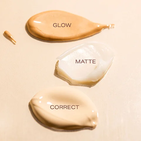 Three swatches of cosmetic product, tan labeled GLOW, white labeled MATTE, and beige labeled CORRECT.