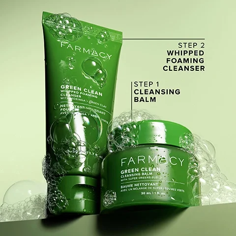 Image 3 - The image shows two green Farmacy Green Clean skincare products, a jar and a tube, covered in soap bubbles on a light green background; the jar is identified as Step 1 Cleansing Balm and its label reads FARMACY GREEN CLEAN CLEANSING BALM WITH SUPER GREENS BLEND BAUME NETTOYANT AVEC UN MÉLANGE DE SUPER LÉGUMES VERTS 30 ml | 1 fl. oz., while the tube is identified as Step 2 Whipped Foaming Cleanser and its label reads FARMACY GREEN CLEAN WHIPPED FOAMING CLEANSER WITH MORINGA + GREEN CLAY NETTOYANT MOUSSANT FOUETTE AVEC MORINGA + ARGILE VERTE 50 ml | 1.7 fl. oz.